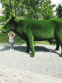 Full length of boy standing by tree