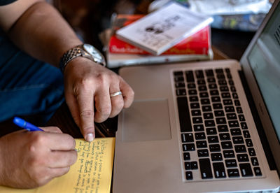 Midsection of man using laptop on table