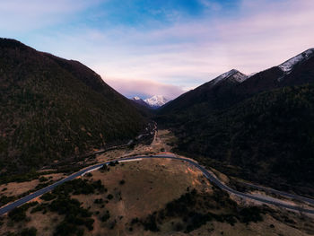 Panoramic view of road amidst mountains against sky during sunset