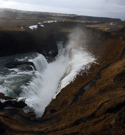 Scenic view of waterfall against sky