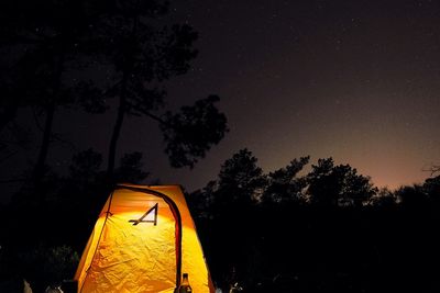 Low angle view of illuminated tent against sky at night