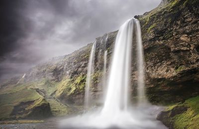 Scenic view of seljalandsfoss against cloudy sky