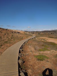 Scenic view of road against clear blue sky