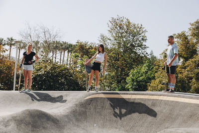 Skateboarders holding skateboards on sports ramp