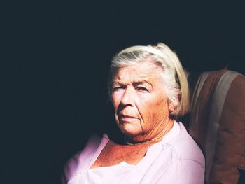 Portrait of woman against black background