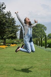 Full length of smiling young woman in park