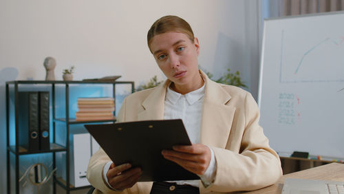 Portrait of businessman using laptop at office