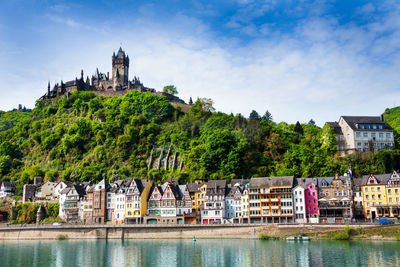 Built structure by river against buildings in city