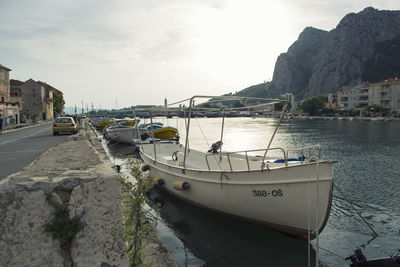 Boats moored at harbor against sky