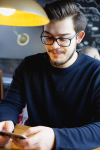 Close-up of young man using smart phone