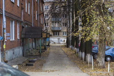 Empty footpath by buildings in city