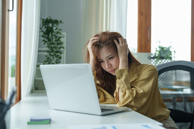 Young woman using laptop at home