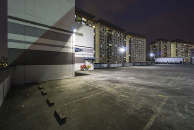 Illuminated street amidst buildings in city at night