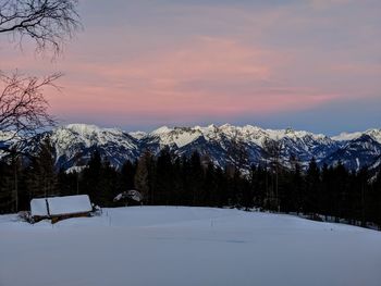 Scenic view of snow covered mountains against sky at sunset