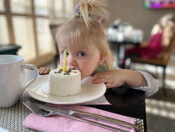 Portrait of young woman using mobile phone on table