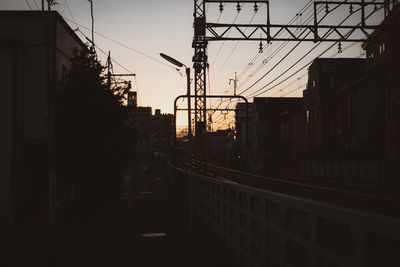 Silhouette buildings in city against sky during sunset