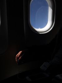 Midsection of person sitting in airplane window