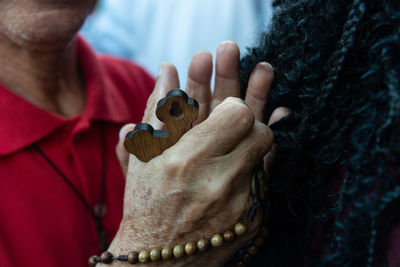 Portrait of hands of a catholic believer holding a rosary during mass. 