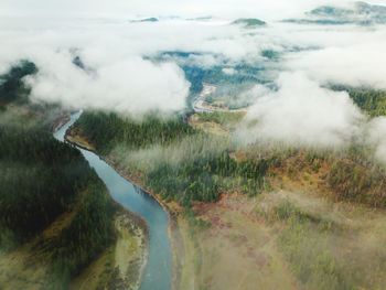 Scenic view of river by mountains against sky