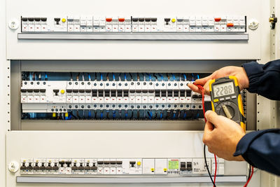 A male electrician works in a switchboard