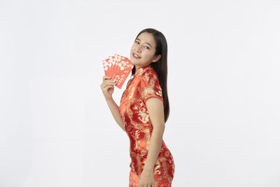 Young woman looking away against white background