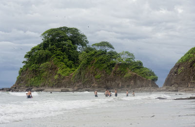 People on beach against sky