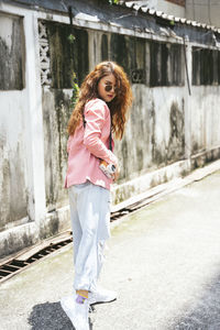 Portrait of girl standing against wall