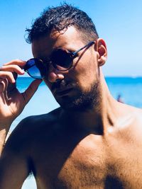 Portrait of shirtless man wearing sunglasses