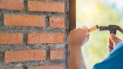 Close-up of man working on wall