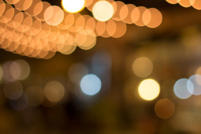 Defocused image of illuminated city against sky at night