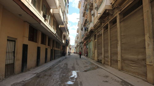 Empty narrow alley amidst buildings in city