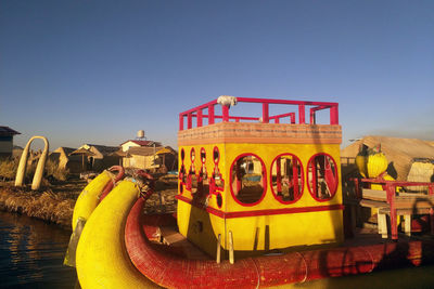 People by swimming pool against clear blue sky