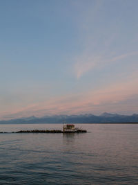 Scenic view of an house on the sea coast against sky during sunset