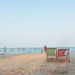 People on beach against clear sky