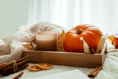 Autumn cozy composition. autumn decoration of pumpkin, candles and fallen leaves 