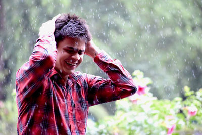 Boy standing in rain and enjoying every moment of it. 