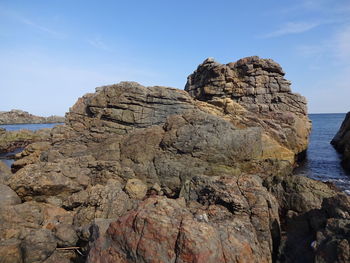 Rock formations in sea against clear sky