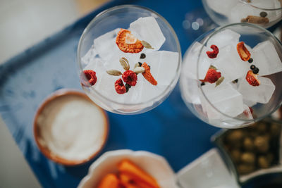 Directly above shot of ice cubes in wineglasses on table