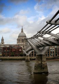 Bridge over river against cloudy sky