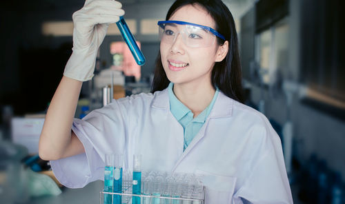 Woman examining chemical in laboratory