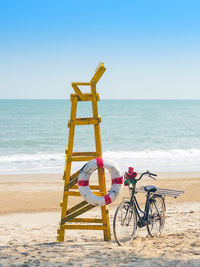 Old retro  bicycle with flowers bouquet beside life ring for life safety on lifeguard stand station 