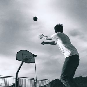 Low angle view of man playing basketball at court