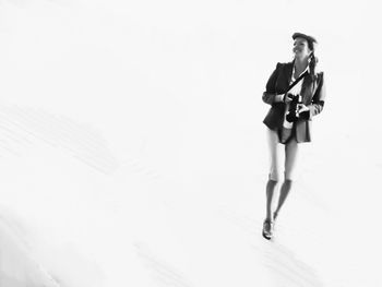 Full length of woman standing against white background