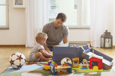 Father and baby boy playing with toys at home