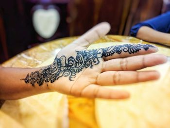 Close-up of cropped woman hand with henna tattoo