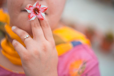 Close-up of hand holding red flower