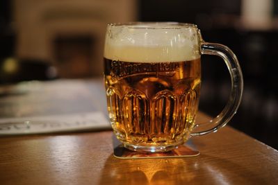 Close-up of beer glass on table