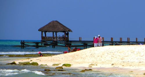 Lifeguard hut on beach against clear blue sky