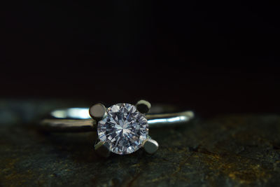 Close-up of diamond ring against black background