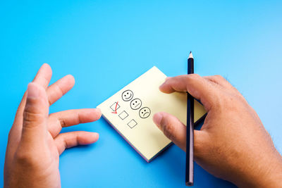 Midsection of person holding text against blue background